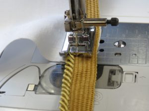 Photo of stopping close to corner when attaching cording for Christmas Pillow. Photo shows cording sitting in groove under foot.