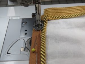 Photo of sewing cording onto top of pillow using invisible zipper foot