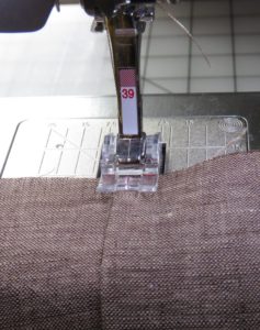 Photo of sewing hem on cutwork tea towel, keeping sewing line 1/8" from edge