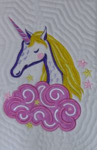 Quilt block of embroidered unicorn using white Madeira supertwist metallic thread