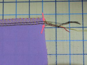 Photo of four thread overlock stitches with needle threads separated. These will be pulled to gather fabric using a serger