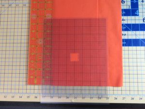 Photo of plastic grid placed on fabric for flannel burp cloth with square cut out for center