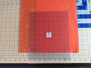 Photo of plastic grid placed on fabric for flannel burp cloth with snowman placed in center