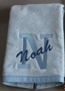 Photo of embroidered flannel burp cloth with ribbon on bottom
