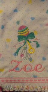Photo of embroidered flannel burp cloth with ribbon and lace on bottom