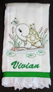 Photo of pre-folded diaper embroidered for a burp cloth featuring a turtle