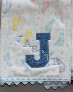 Photo of embroidered flannel burp cloth with ribbon and rick rack on bottom