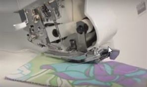 Photo showing when you gather fabric using a serger the ruffle fabric goes face up under the gathering foot.