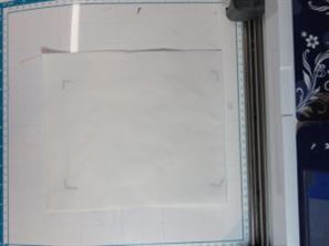 Photo of Mylar sandwiched between two pieces of freezer paper, marked for position on Scan N Cut