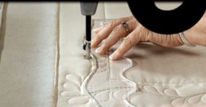 Photo of using a ruler on a Handi Quilter