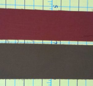 Fabric strips to be used to make flange binding. The red strip is 1 1/2" wide and the brown fabric strip is 2" wide. 