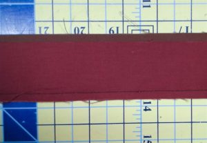 Photo of flange binding with red and brown strips sewn together along long end.