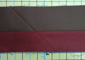 Photo of right side of red and brown flange binding showing seams that connect strips from end to end.