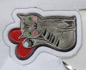 Photo of trimming excess iron-on patch base fabric