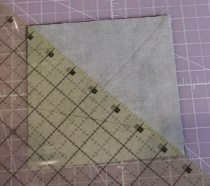 Photo of cutting sewn square to make half-square triangles