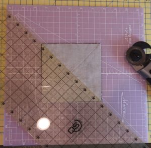 Photo of cutting sewn square to make half-square triangles