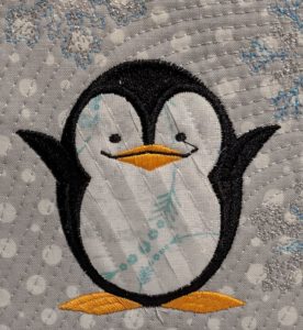 Photo of chenille penguin after features have been embroidered but before chenille is brushed out