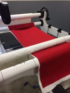 Photo of small quilt sandwich set up on long arm to test tension