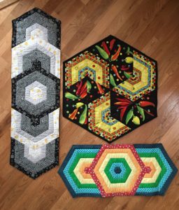 Photo of different table runners made with triangles for Littleton class