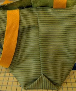 Photo of corner of bag folded up to side seam and stitched in place