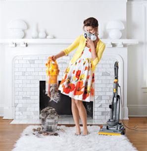 Photo of woman with face mask emptying baggless vacuum cleaner.