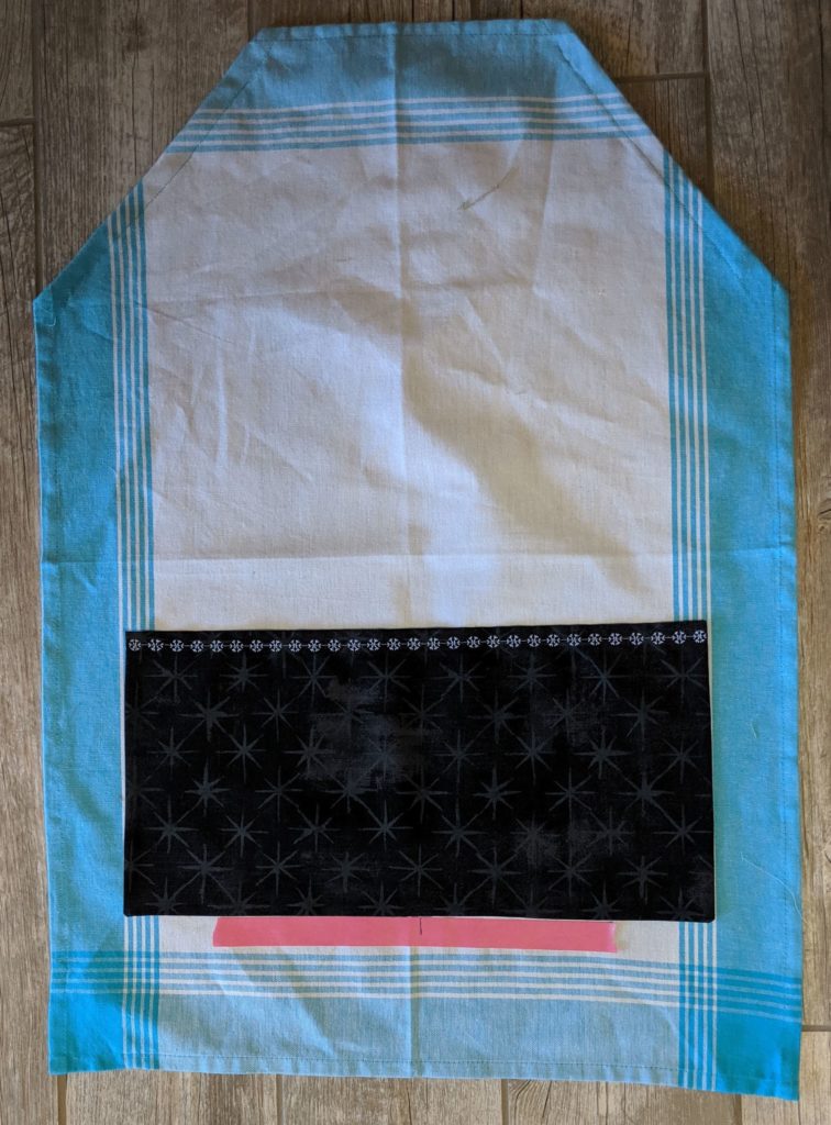 Photo of decorative stitches along top edge of tea towel apron pocket