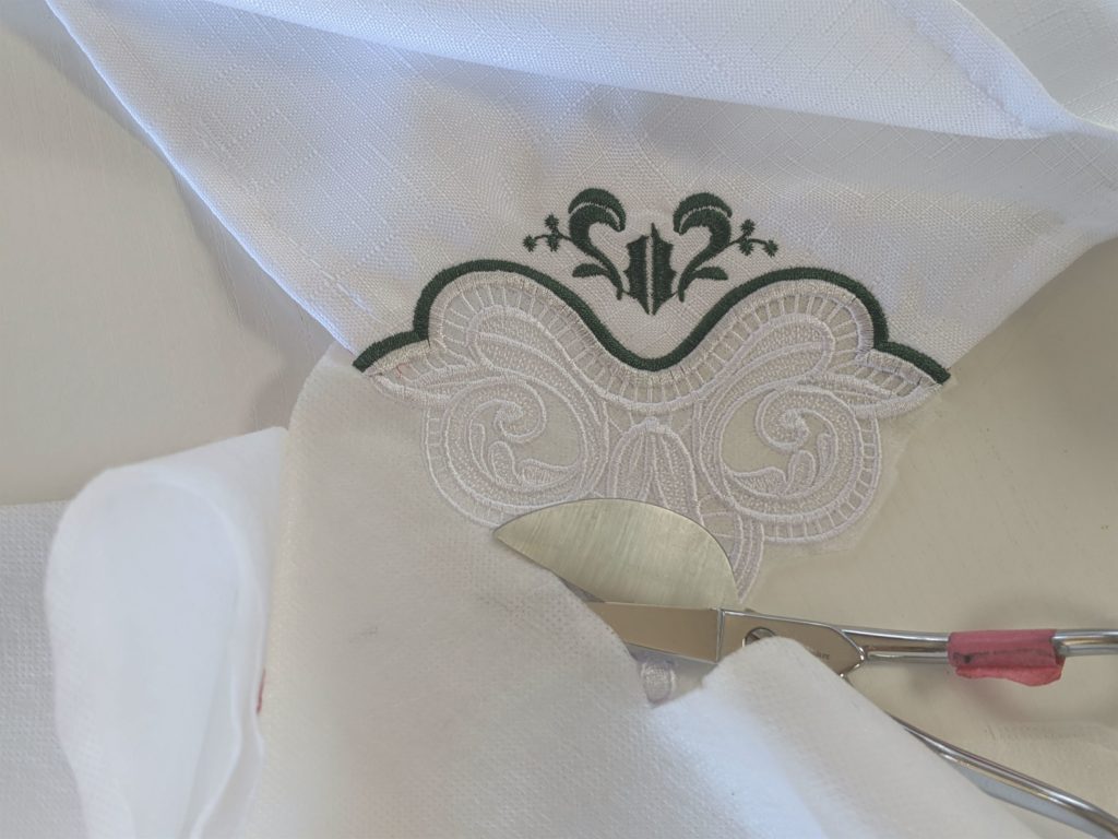 Photo of trimming away excess stabilizer from lace corner napkin